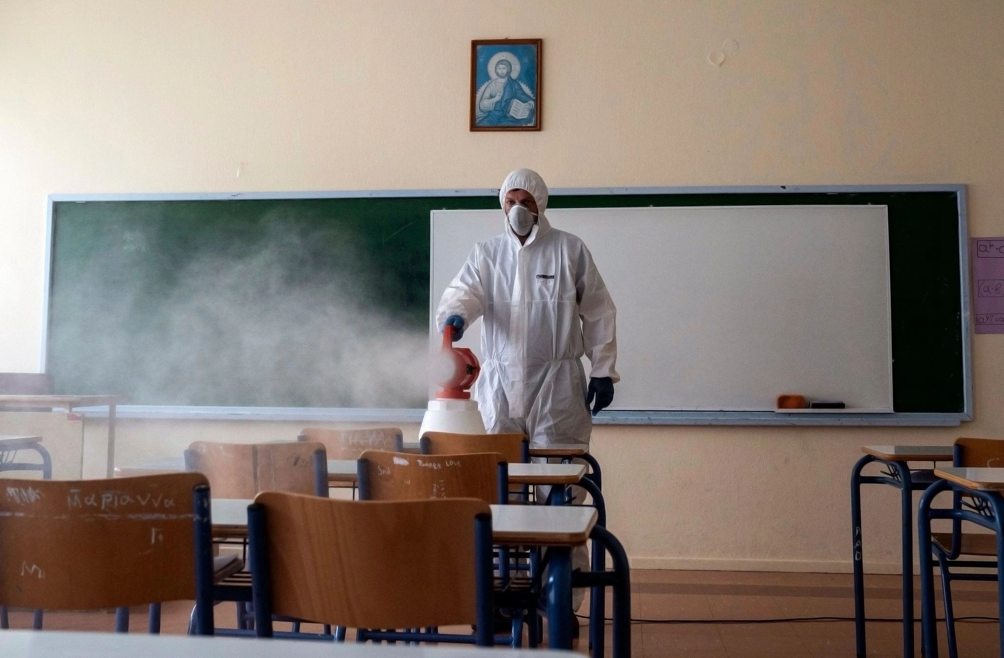 Technician applying MicrobeCare antimicrobial fogging treatment in a classroom